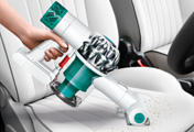 The Dyson V6 Mattress handheld vacuum cleaner. In car cleaning. Cleans footwells, upholstery and beneath car seats.
